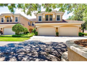 Beautiful two-story townhome featuring a two-car garage and well-manicured landscaping at 54 Camino Real Blvd # 504, Howey In The Hills, FL 34737