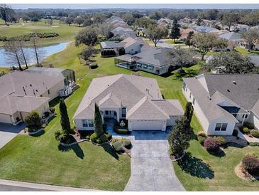 Beautiful aerial view of a single-story home with well-manicured lawn, mature landscaping, and a golf course nearby at 7812 Se 167Th Mistwood Ln, The Villages, FL 32162
