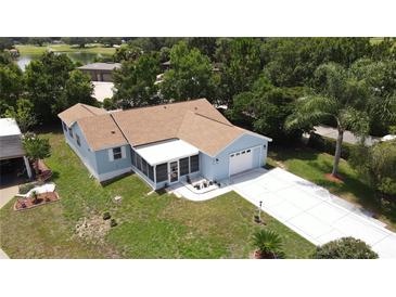 Charming blue single-story home with well-manicured lawn and attached one car garage at 1416 Lindsey Ln, The Villages, FL 32159