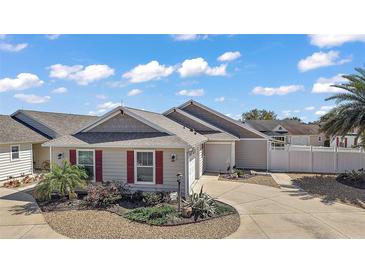 Charming home featuring meticulous landscaping, light colored siding, and a quaint front garden at 1781 Kingfisher Ct, The Villages, FL 32162