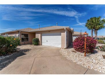 Charming single-story home featuring a well-manicured lawn and a convenient one-car garage at 1802 Dalton Dr, The Villages, FL 32162