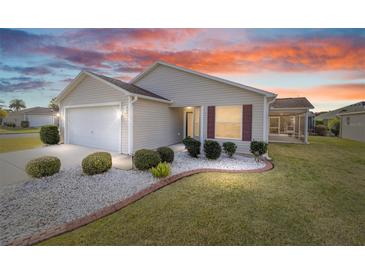 Charming single-story home with manicured lawn, stone accents, and an attached two-car garage at 2046 Dalecroft Trl, The Villages, FL 32162