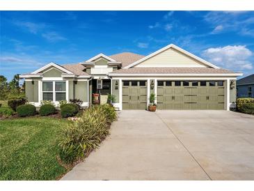 Charming single-story home with a well-manicured lawn and a three-car garage at 2124 Biller Cir, The Villages, FL 32163