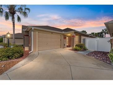 Charming single Gathering home with a two-car garage, mature landscaping and beautiful evening sky at 483 Cammarano Pl, The Villages, FL 32162