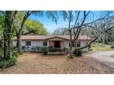 Charming single-story home featuring a cozy front porch and mature trees at 1236 Selman Rd, Leesburg, FL 34748