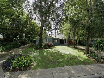 Charming single-story home with a well-manicured lawn and mature trees providing ample shade in the front yard at 186 S Sunset Dr, Mount Dora, FL 32756