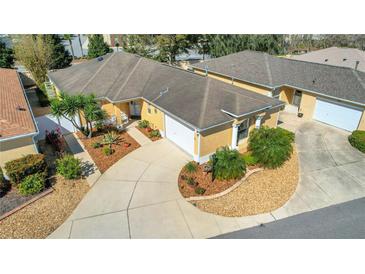 Aerial shot of a charming home featuring a well-manicured front yard with mature trees and an extended driveway at 2165 Smoaks St, The Villages, FL 32162