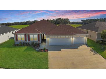 Spacious home featuring a large three-car garage and well-manicured lawn, perfect for Gathering living at 3290 Sennett Cir, Oxford, FL 34484