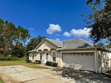 Charming single-story home featuring an attached two-car garage, and well-maintained landscaping at 390 Colonade Ct, Kissimmee, FL 34758