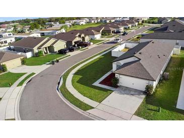 Aerial view of a charming residential neighborhood with well-maintained lawns and sidewalks at 440 Kensington View Dr, Winter Haven, FL 33880