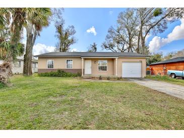 Charming single-story home with a well-maintained lawn, attached garage, and inviting front entrance at 7036 Clarcona Ocoee Dr, Orlando, FL 32818