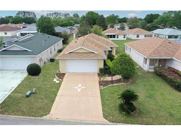 Charming one-story home featuring a well-manicured lawn, inviting driveway, and attached garage at 9481 Sw 93Rd Loop, Ocala, FL 34481