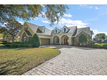 Inviting home with stone accents, paver driveway, and well-manicured lawn at 1075 Ceasars Ct, Mount Dora, FL 32757