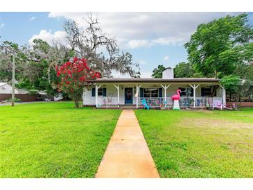 Charming single-story home featuring a well-manicured lawn and a quaint front porch at 132 E Belt Ave, Bushnell, FL 33513