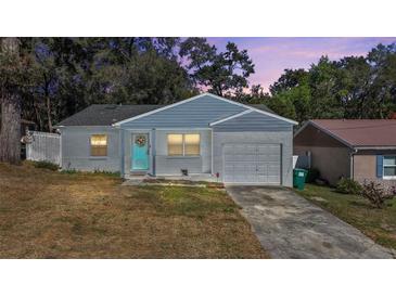 Charming single Gathering home with a garage, colorful door and landscaped yard at 151 Shiloh Ave, Lady Lake, FL 32159