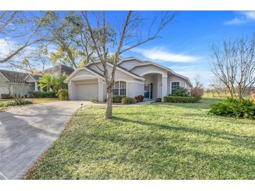 Charming single-story home featuring a well-manicured lawn and attached two car garage at 16839 Rockwell Heights Ln, Clermont, FL 34711