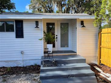 Charming front entrance featuring white siding, double doors, and tasteful landscaping at 1700 Hollywood Ave, Eustis, FL 32726