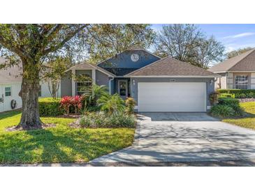 Charming home featuring a well-manicured lawn, vibrant landscaping, and a two-car garage at 3773 Eversholt St, Clermont, FL 34711