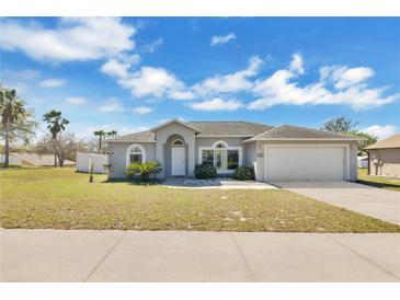 Charming single-story home featuring a well-maintained lawn, two-car garage and a welcoming entrance at 1391 Willow Crest Dr, Clermont, FL 34711