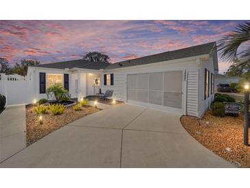 Charming single-story home featuring a well-manicured yard, a two-car garage, and a warm, inviting entrance at 16800 Se 80Th Bathurst Ct, The Villages, FL 32162