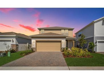 Charming two-story home featuring a brick driveway, neutral siding and a well-manicured lawn at 17291 Saw Palmetto Ave, Clermont, FL 34714