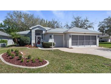 Charming single-story home with a well-manicured lawn and mature landscaping at 20740 Queen Alexandra Dr, Leesburg, FL 34748