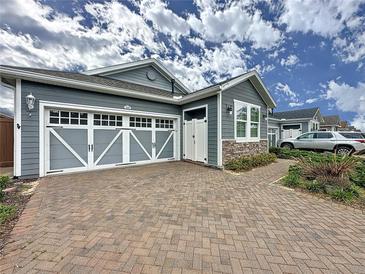 Charming single-Gathering home boasting a brick driveway and stylish garage doors at 345 Alcove Dr, Groveland, FL 34736