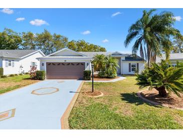 Charming single-story home features a two-car garage, tropical landscaping, and a well-manicured lawn at 3909 River Crest Cir, Leesburg, FL 34748