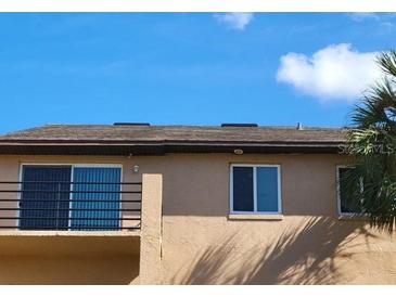 Exterior shot of home showing windows and upper balcony with railing and palm trees at 5214 Via Hacienda Cir # A308, Orlando, FL 32839