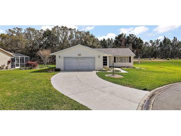 Charming single-story home with a well-manicured lawn and long driveway leading to an attached garage at 6022 Wilander St, Leesburg, FL 34748
