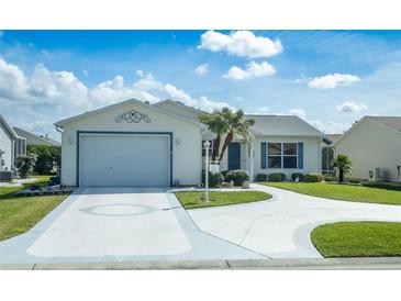 Charming single-story home with a well-manicured lawn, a two-car garage and a clean, painted driveway at 773 Artesia Ave, The Villages, FL 32162