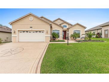Charming single-story home with a well-manicured lawn, neat landscaping, and a two-car garage at 10929 Se 167Th Pl, Summerfield, FL 34491