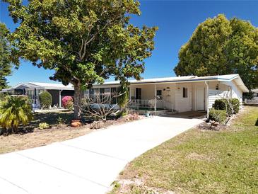 Charming single-story home with a well-maintained lawn, mature trees, and a paved driveway leading to the front entrance at 1340 Elkhart Cir, Tavares, FL 32778