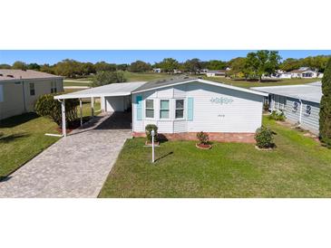 Charming single-story home with a well-manicured lawn, covered parking, and quaint curb appeal at 1510 E Schwartz Blvd, The Villages, FL 32159