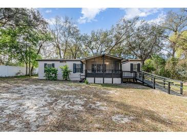 Charming home with light siding, black shutters, wheelchair ramp and a screened in porch at 1638 Leesburg Blvd, Fruitland Park, FL 34731