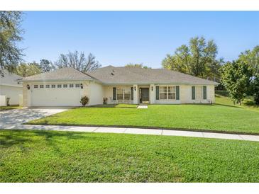 Charming single-story home boasts a well-manicured lawn, attached garage, and inviting front porch, perfect for curb appeal at 1792 Presidio Dr, Clermont, FL 34711