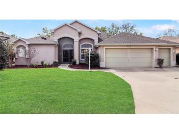 Charming single-story home with a well-manicured lawn and a two-car garage at 20755 Queen Alexandra Dr, Leesburg, FL 34748
