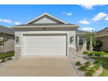 Charming single-story home features an attached two-car garage and well-manicured landscaping at 2174 Wallingford Loop, Mount Dora, FL 32757