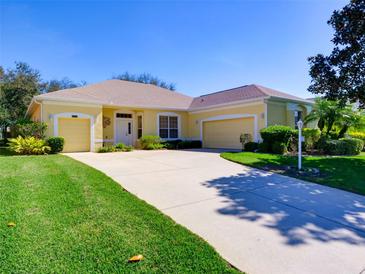 Well-maintained home boasts a three-car garage, manicured lawn, and a long, paved driveway at 24104 Robinwood St, Leesburg, FL 34748