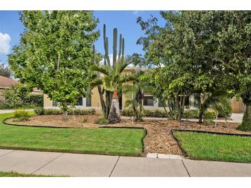 Well-manicured front yard with lush landscaping and a variety of trees and plants at 257 Winding Cove Ave, Apopka, FL 32703