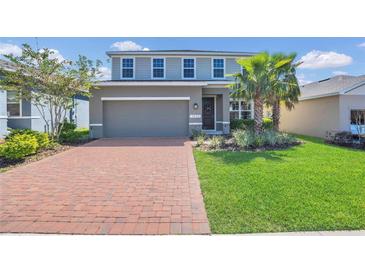 Beautiful home featuring a brick driveway, lush lawn, and manicured landscaping at 3054 Hill Point St, Minneola, FL 34715