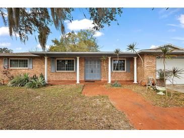 Charming single story home with brick exterior, covered entryway, and mature landscaping at 33311 Green Rd, Leesburg, FL 34788