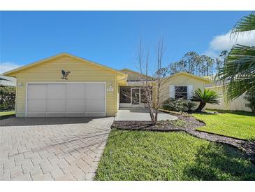 Charming single-story home with a well-maintained lawn and an attached two-car garage at 341 Ranchwood Dr, Leesburg, FL 34748