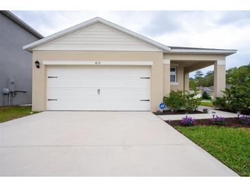 Charming single-story home featuring a two-car garage, well-maintained lawn, and manicured shrubbery at 412 Lady Bella Pl, Deland, FL 32724