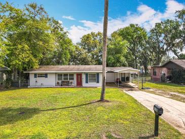 Inviting single-story home featuring a well-kept lawn and convenient covered parking at 1108 Cedar St, Leesburg, FL 34748