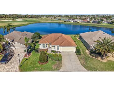 Inviting home with manicured lawn, landscaping and a peaceful lake and golf course view at 1197 Eureka Mill Run, The Villages, FL 32162