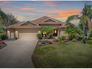 Well-maintained home exterior with mature landscaping and a three-car garage at 1239 Russell Loop, The Villages, FL 32162