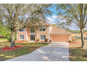 Charming two-story home with manicured lawn and mature trees in a desirable neighborhood at 12620 Bay Breeze Ct, Clermont, FL 34711