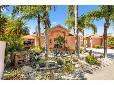 Charming home's front yard features a variety of tropical landscaping, palm trees, and a cozy outdoor seating area at 1502 Aalto Pl, Lady Lake, FL 32159