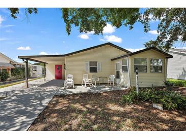 Inviting single-story home featuring a covered parking area and a cozy outdoor seating space at 1729 Lauren Ln, Lady Lake, FL 32159